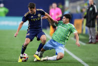 Vancouver Whitecaps midfielder Alessandro Schopf, left, vies for the ball against Seattle Sounders midfielder Obed Vargas, right, during the first half of an MLS soccer match Saturday, April 20, 2024, in Seattle. (AP Photo/Lindsey Wasson)