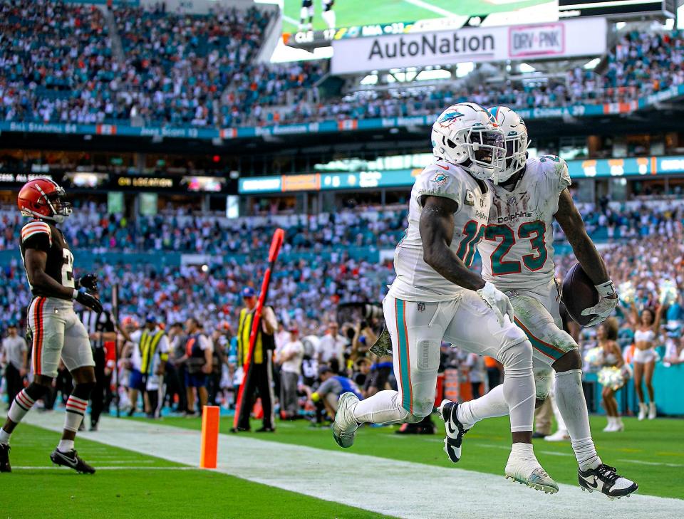 Dolphins receiver Tyreek Hill (10) and running back Jeff Wilson Jr. celebrate after Wilson scored late in the fourth quarter against the Browns Sunday at Hard Rock Stadium.