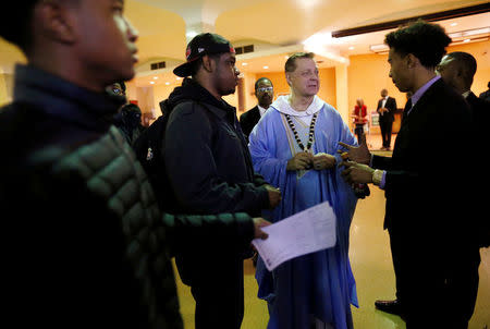 Father Michael Pfleger (2nd R) speaks to Justin Irving (R) and Kristopher Williams (2nd L) after a Sunday Service at Saint Sabina Church in Chicago, Illinois, U.S., December 4, 2016. REUTERS/Jim Young