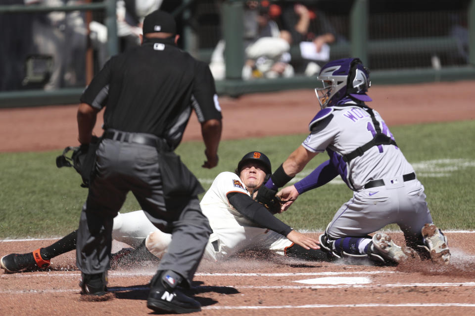 San Francisco Giants' Wilmer Flores is tagged out at home by Colorado Rockies' Tony Wolters during the second inning of a baseball game in San Francisco, Thursday, Sept. 24, 2020. (AP Photo/Jed Jacobsohn)