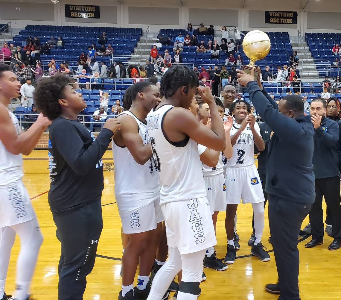 Mansfield Summit coach Emund Prichett hoists the Class 5A Region I quarterfinal trophy in front of his Jaguars after a 61-37 win over Mansfield Timberview on February 28, 2023 at Mansfield High School in Mansfield, Texas.