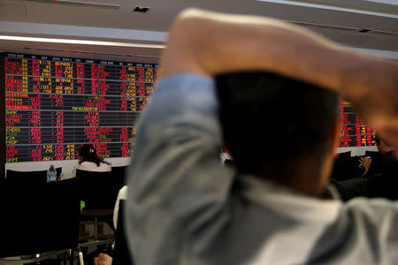 People monitor a stock index board at a bank in Bangkok, Thailand, February 6, 2018. REUTERS/Athit Perawongmetha