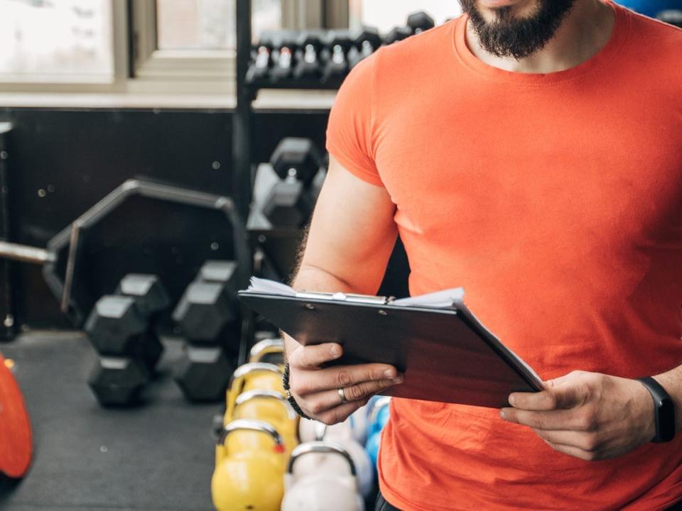 a fitness instructor athlete looking at a training schedule in the gym