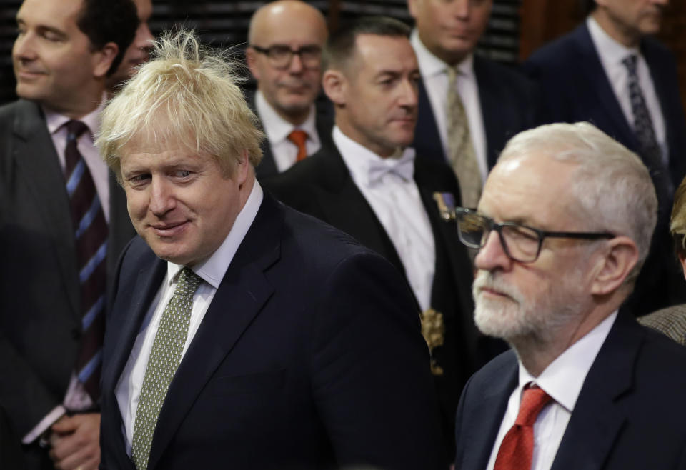 Britain's Prime Minister Boris Johnson, left, and opposition Labour Party Leader Jeremy Corbyn, walk through the Commons Members Lobby, during the state opening of Parliament, in London, Thursday, Dec. 19, 2019. Queen Elizabeth II formally opened a new session of Britain's Parliament on Thursday, with a speech giving the first concrete details of what Prime Minister Boris Johnson plans to do with his commanding House of Commons majority. (AP Photo/Kirsty Wigglesworth, Pool)