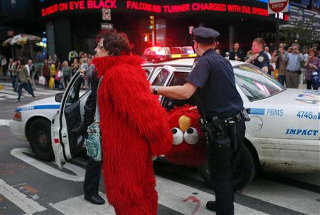 Dan Sandler, dressed as the Muppet character Elmo, is handcuffed and detained by police after using anti-Semitic language in Times Square, New York, in this file picture taken September 18, 2012. REUTERS/Adrees Latif/Files