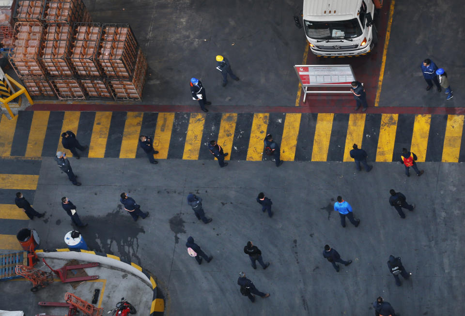 Employees of a bottled water company stand at a distance from each other as they prepare to distribute drinking water in Mexico City, Friday, May 8, 2020. Mexico woke up to news of its largest one-day increase in confirmed cases of COVID-19, from Wednesday to Thursday. (AP Photo/Marco Ugarte)