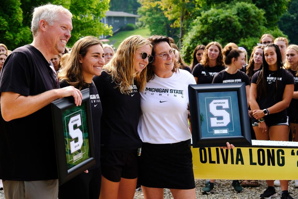 The parents of Olivia Long, Mike Long and Arana Long pose with framed varsity letters Saturday, Sept. 17, 2022.