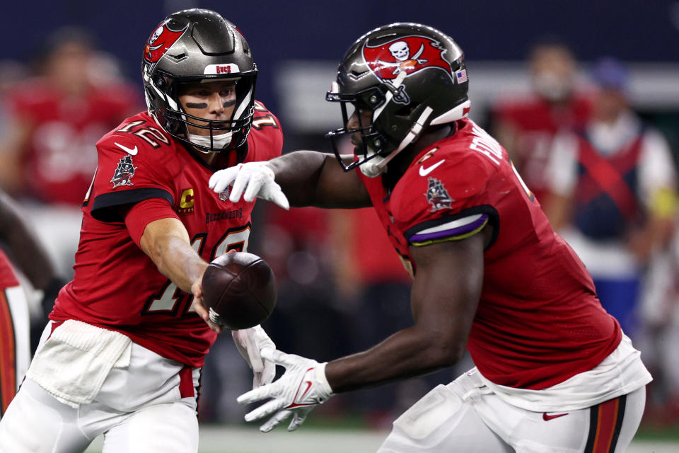 Tom Brady #12 of the Tampa Bay Buccaneers hands the ball off to Leonard Fournette #7 