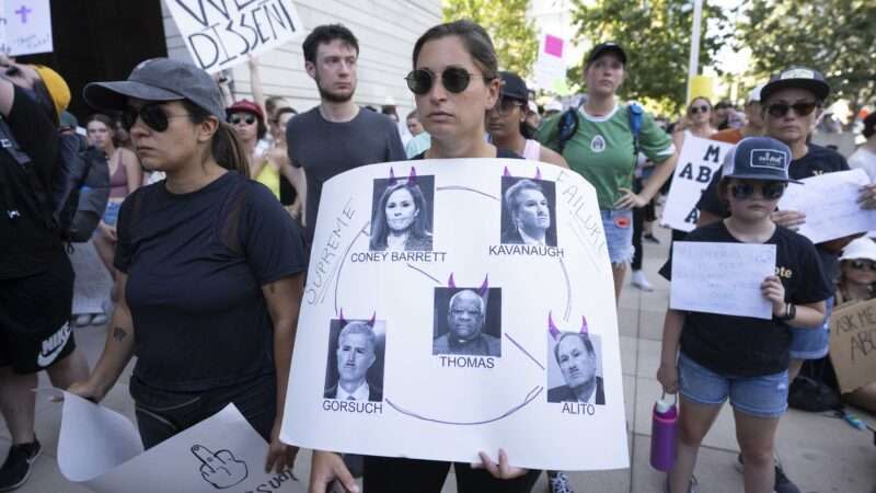 Female protester holds sign protesting abortion ruling