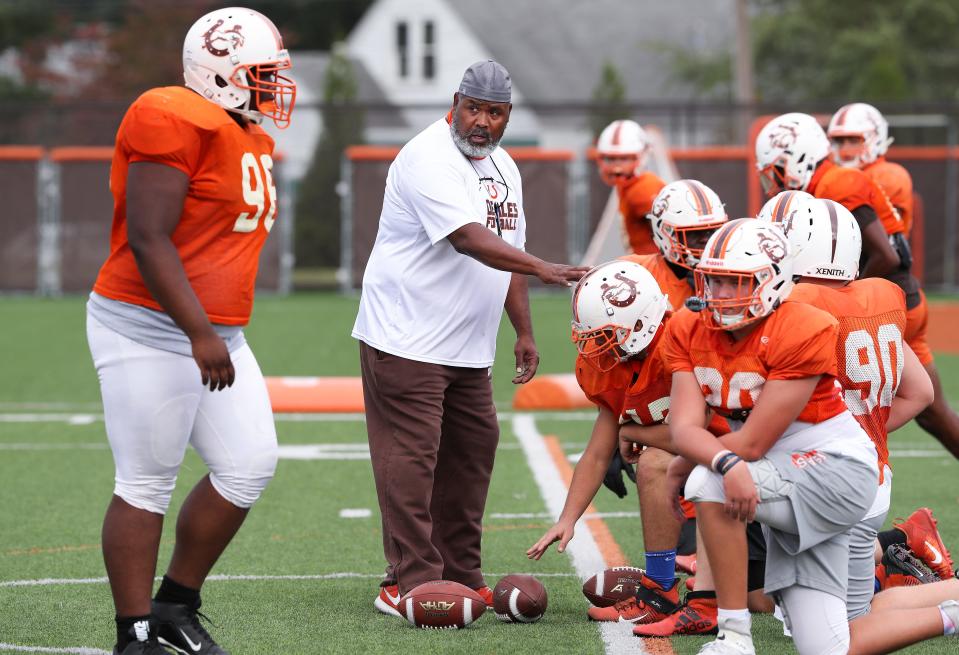 DeSales offensive coordinator Ty Scroggins, center, gives instruction to the offensive line during practice at the school in Louisville, Ky. on Sept. 22, 2020.  