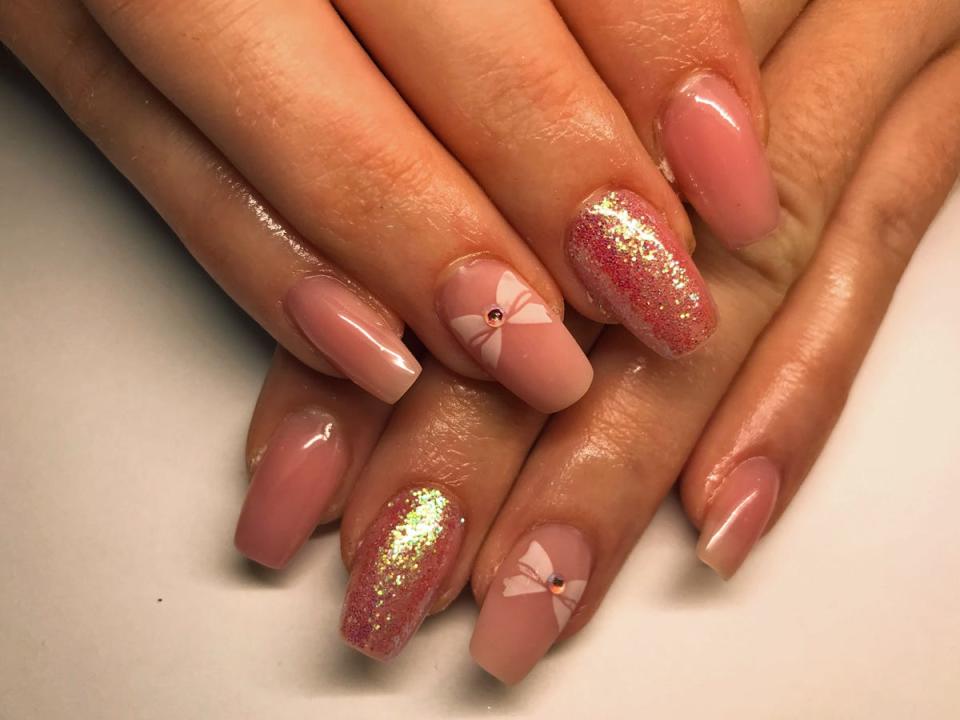 Pink manicure with bow accents.