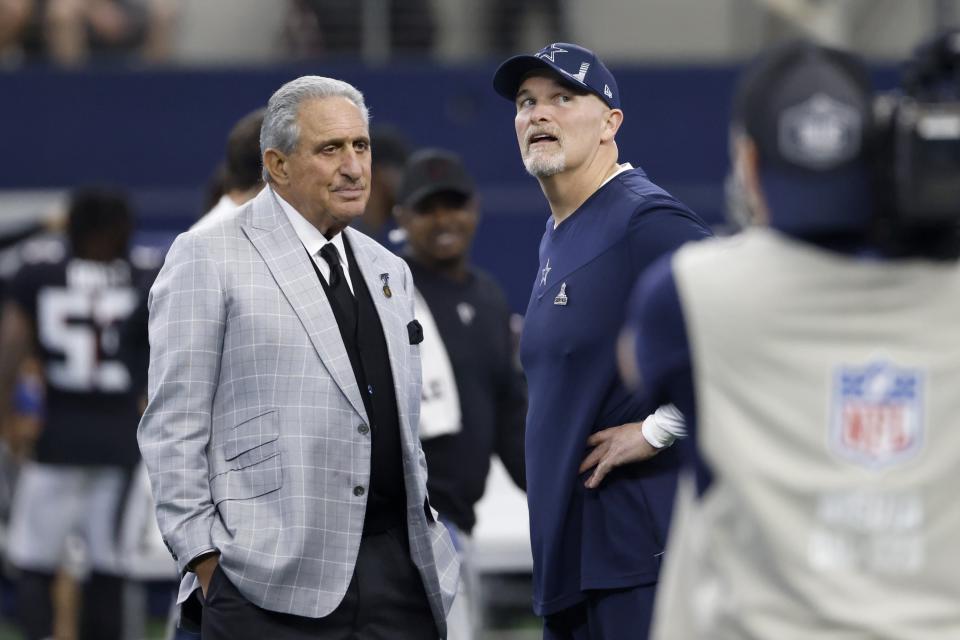 Atlanta Falcons team owner Arthur M. Blank, left, talks with Dallas Cowboys defensive coordinator Dan Quinn, right, during team warmups before an NFL football game in Arlington, Texas, Sunday, Nov. 14, 2021. (AP Photo/Ron Jenkins)