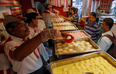 Customers purchase ‘Rosogolla’, popularly known as the king of Indian sweets, inside a sweet shop in Kolkata, India, November 14, 2017. REUTERS/Rupak De Chowdhuri