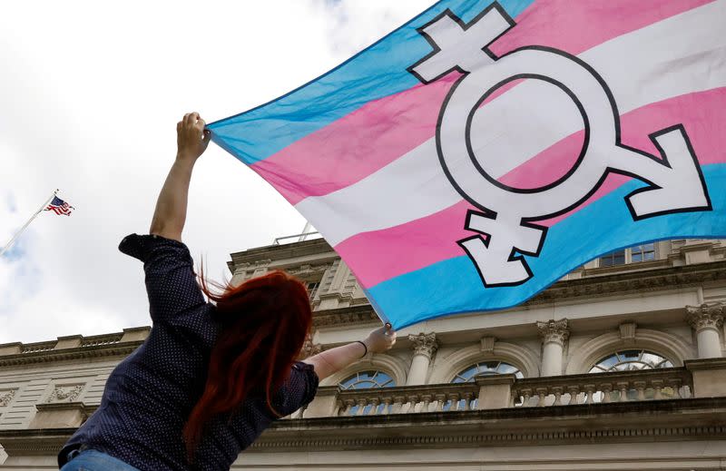 FILE PHOTO: A person holds up a flag during rally to protest the Trump administration's reported transgender proposal to narrow the definition of gender to male or female at birth in New York