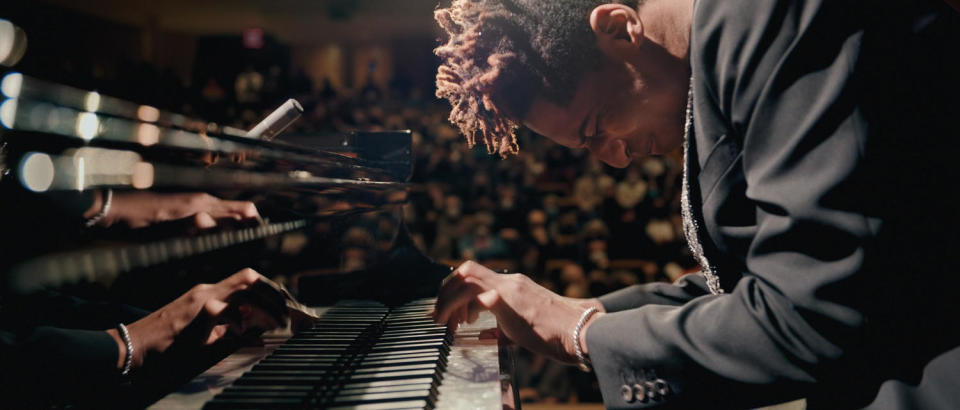 Jon Batiste on the piano during a concert in 