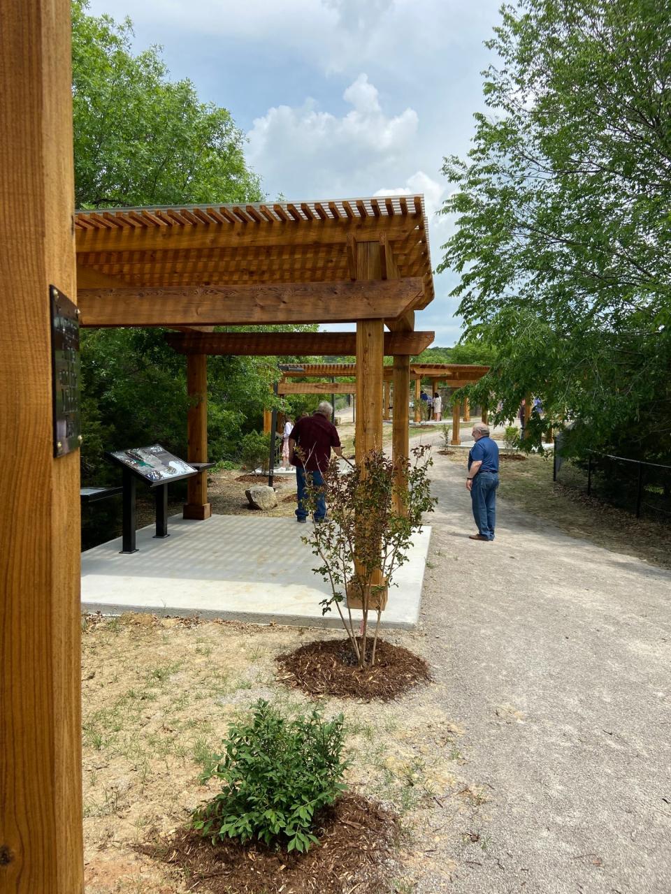 Visitors walk along the Missions Trail recently in the Centennial Prayer Garden at Falls Creek Baptist Camp & Conference Center near Davis.