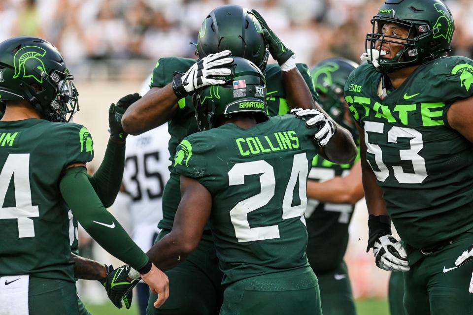 Michigan State's Elijah Collins, center, celebrates his touchdown against Akron during the third quarter on Saturday, Sept. 10, 2022, at Spartan Stadium in East Lansing.