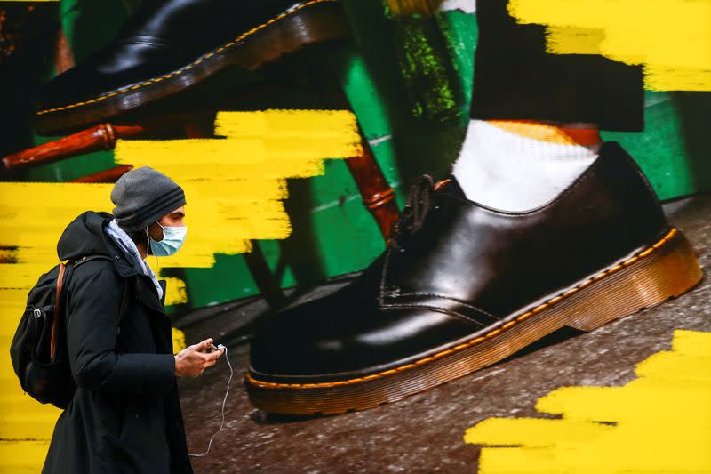 FILE PHOTO: A woman walks past the window of a "Dr Martens" shoe shop amid the coronavirus disease (COVID-19) outbreak in central Madrid