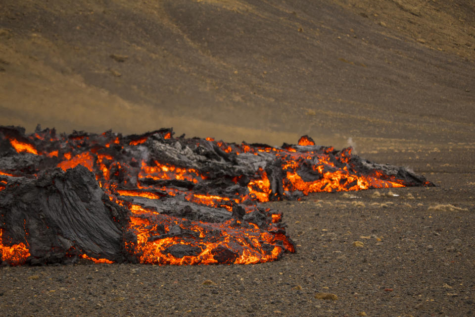 Lava flows from a new fissure on a volcano on the Reykjanes Peninsula in southwestern Iceland, Monday, April 5, 2021. The new fissure has opened up at the Icelandic volcano that began erupting last month, prompting the evacuation of hundreds of hikers who had come to see the spectacle. Officials say the new fissure is about 500 meters (550 yards) long and about one kilometer (around a half-mile) from the original eruption site in the Geldinga Valley (AP Photo/Marco Di Marco)