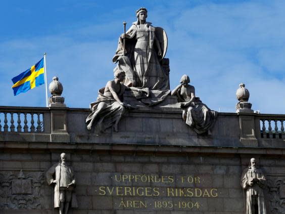 The Swedish flag flutters next to the country's Parliament, where politicians have voted to introduce new rape laws (REUTERS)