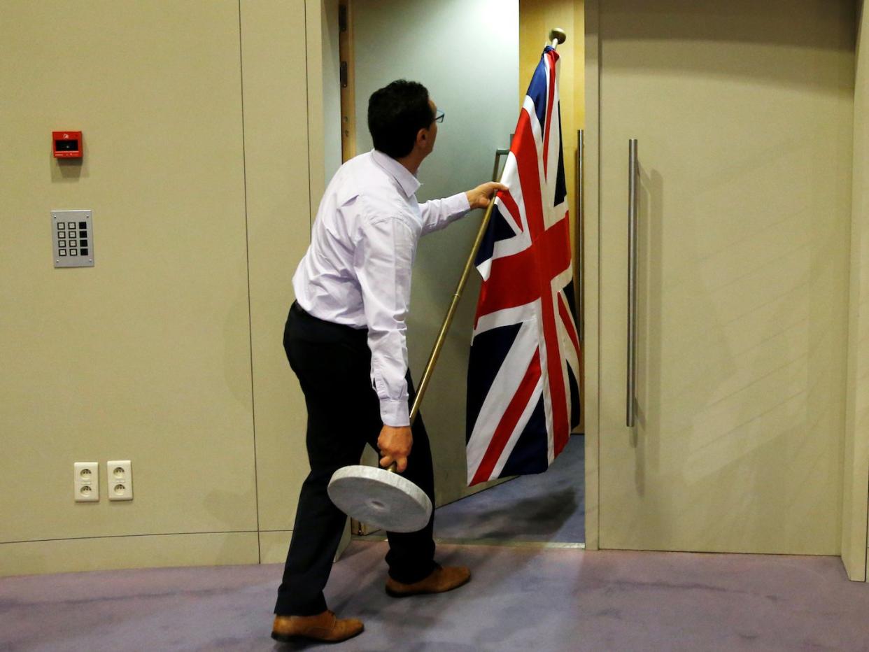 An official carries a Union Jack flag ahead of a news conference by Britain's Secretary of State for Exiting the European Union David Davis and European Union's chief Brexit negotiator Michel Barnier in Brussels, Belgium July 20, 2017.