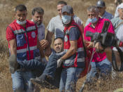 Paramedics evacuate a Palestinian man after scuffling with Israeli border police while trying to reach olive groves for harvest, in the West Bank village of Burqa, East of Ramallah, Friday, Oct. 16, 2020. Palestinians clashed with Israeli border police in the West Bank on Friday during their attempt to reach and harvest their olive groves near a Jewish settlers outpost. (AP Photo/Nasser Nasser)