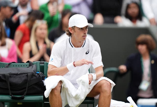 Alex De Minaur looks concerned as he sits on his seat