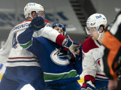 Vancouver Canucks left wing Nils Hoglander (36) fights for control of the puck with Montreal Canadiens defenceman Joel Edmundson (44) and Canadiens right wing Josh Anderson (17) during second period NHL action in Vancouver, Monday, March 8, 2021. (Jonathan Hayward/The Canadian Press via AP)