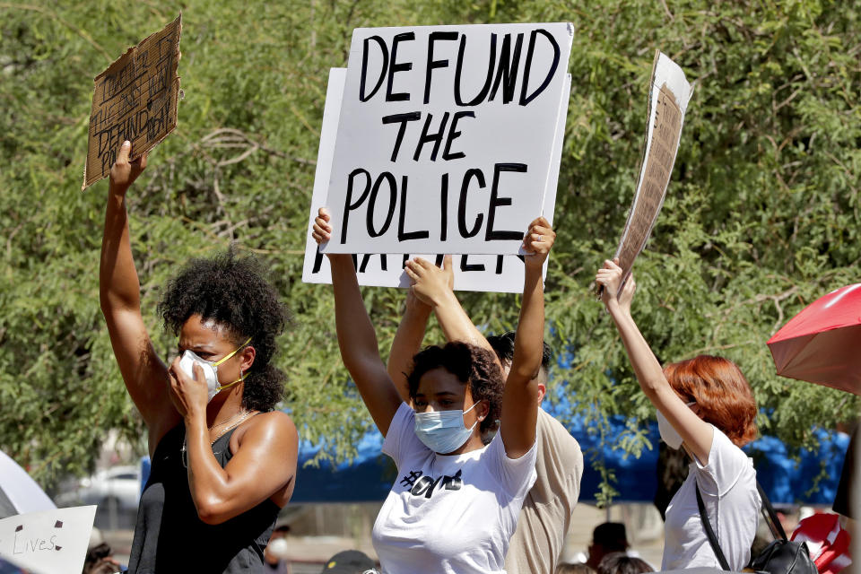 Protesters rally Wednesday, June 3, 2020, in Phoenix, demanding the Phoenix City Council defund the Phoenix Police Department. The protest is a result of the death of George Floyd, a black man who died after being restrained by Minneapolis police officers on May 25. (AP Photo/Matt York)