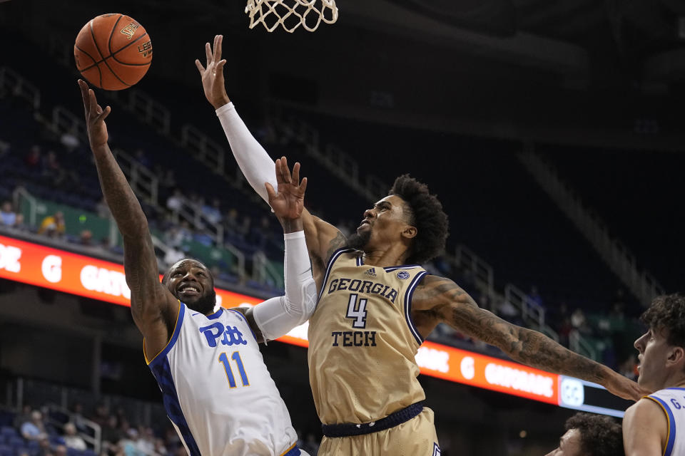 Pittsburgh guard Jamarius Burton shoots over Georgia Tech forward Javon Franklin during the second half of an NCAA college basketball game at the Atlantic Coast Conference Tournament, Wednesday, March 8, 2023, in Greensboro, N.C. (AP Photo/Chris Carlson)