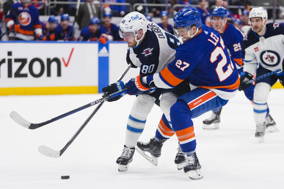 Winnipeg Jets' Pierre-Luc Dubois (80) fights for control of the puck with New York Islanders' Anders Lee (27) during the first period of an NHL hockey game Wednesday, Feb. 22, 2023, in Elmont, N.Y. (AP Photo/Frank Franklin II)