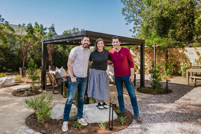 <p>HGTV </p> Mayim Bialik poses with Drew and Jonathan Scott.