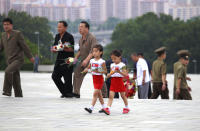 Children carry flowers to the statues of President Kim Il Sung and Chairman Kim Jong Il on Mansu Hill to commemorate the 77th anniversary of Korea's Liberation in Pyongyang, North Korea, Monday, Aug. 15, 2022. (AP Photo/Cha Song Ho)