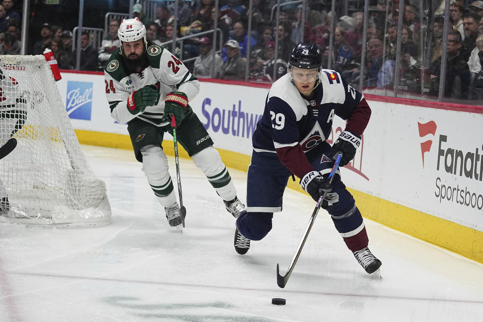 Colorado Avalanche center Nathan MacKinnon (29) handles the puck in the second period of an NHL hockey game against the Minnesota Wild Tuesday, April 9, 2024, in Denver. (AP Photo/Bart Young)