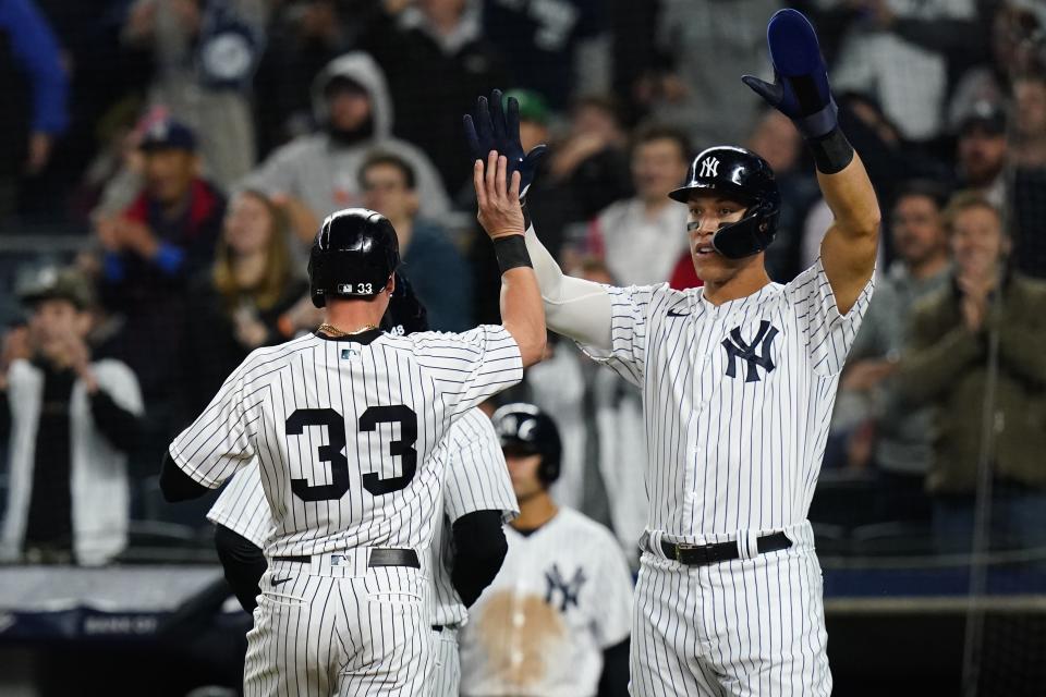 New York Yankees' Aaron Judge, right, celebrates with Tim Locastro, left, after they scored on a Gleyber Torres three-run triple during the seventh inning of a baseball game against the Baltimore Orioles, Tuesday, April 26, 2022, in New York. (AP Photo/Frank Franklin II)