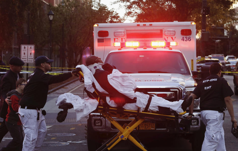 <p>Emergency personnel transport a man on a stretcher after a motorist drove onto a busy bicycle path near the World Trade Center memorial and struck several people, Oct. 31, 2017, in New York. (Photo: Mark Lennihan/AP) </p>