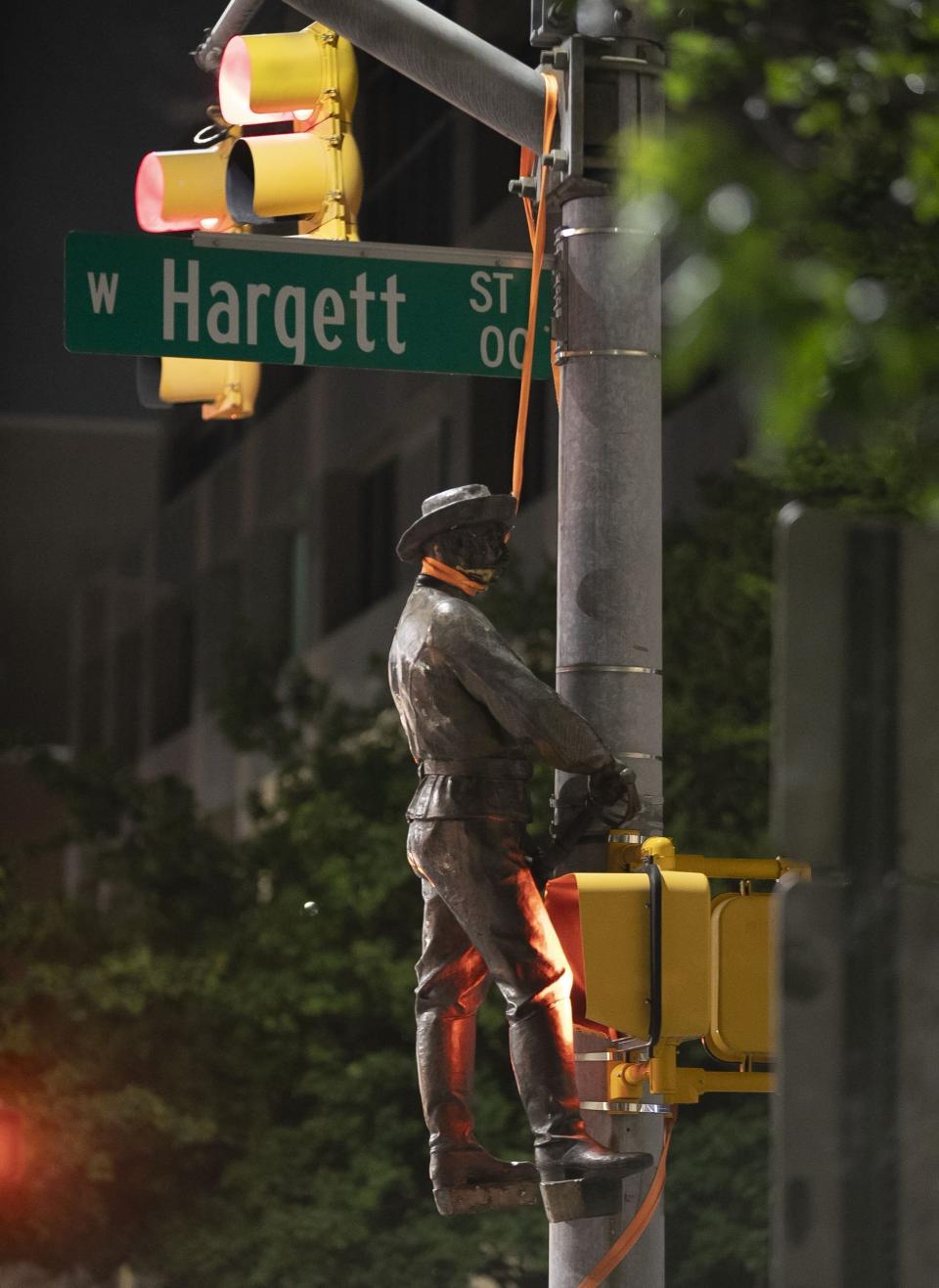 One of the Confederate statues that was felled from the Confederate monument on the west side of the North Carolina State Capitol by protesters is hung over a utility pole at the corner of Salisbury Street and Hargett Street, on Friday, June 19, 2020, in Raleigh, N.C. (Robert Willett/The News & Observer via AP)