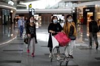 People wearing face masks are seen at the Beijing Daxing International Airport, ahead of Chinese National Day holiday, in Beijing