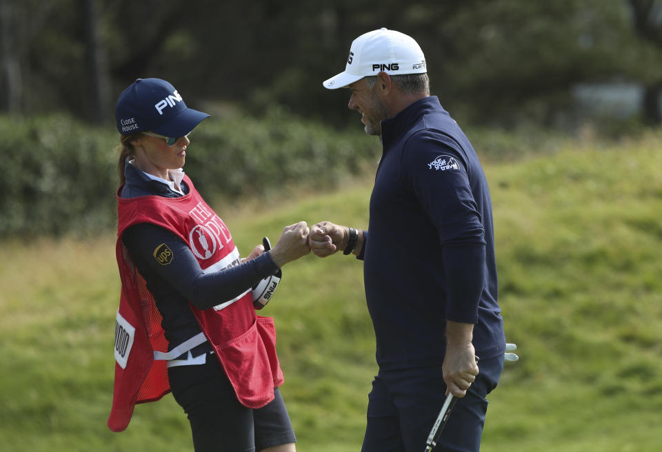 England's Lee Westwood touches fists with his caddie and girlfriend Helen Storey after getting a birdie on the 4th green during the third round of the British Open Golf Championships at Royal Portrush in Northern Ireland, Saturday, July 20, 2019.(AP Photo/Jon Super)