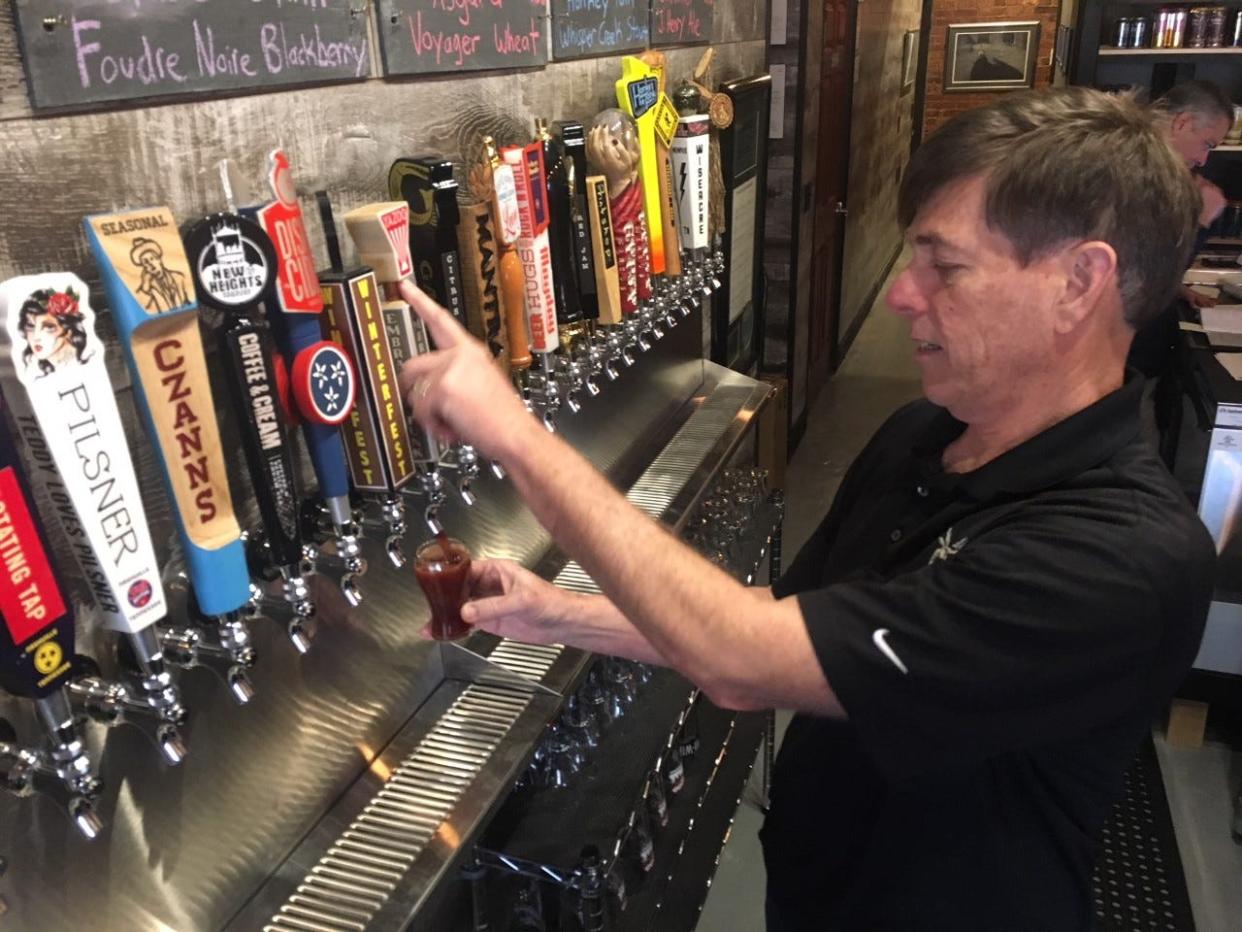 Mark Cook pours a tester of one of his beers for a customer on Feb. 3, 2020.