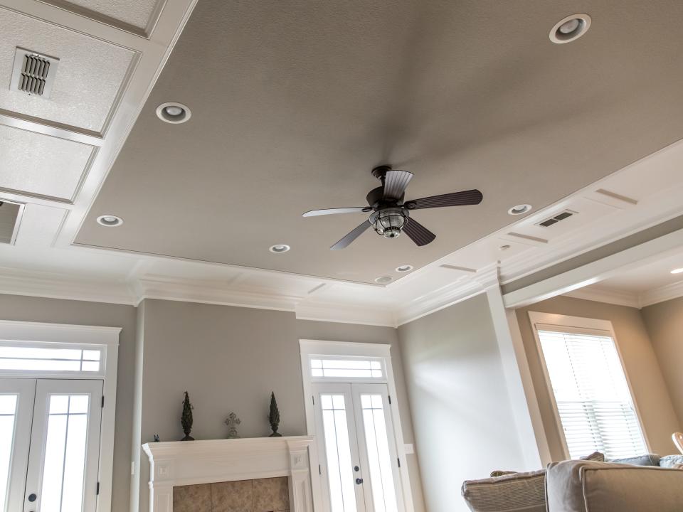 Greige on a wall and a ceiling with a fan and white trim