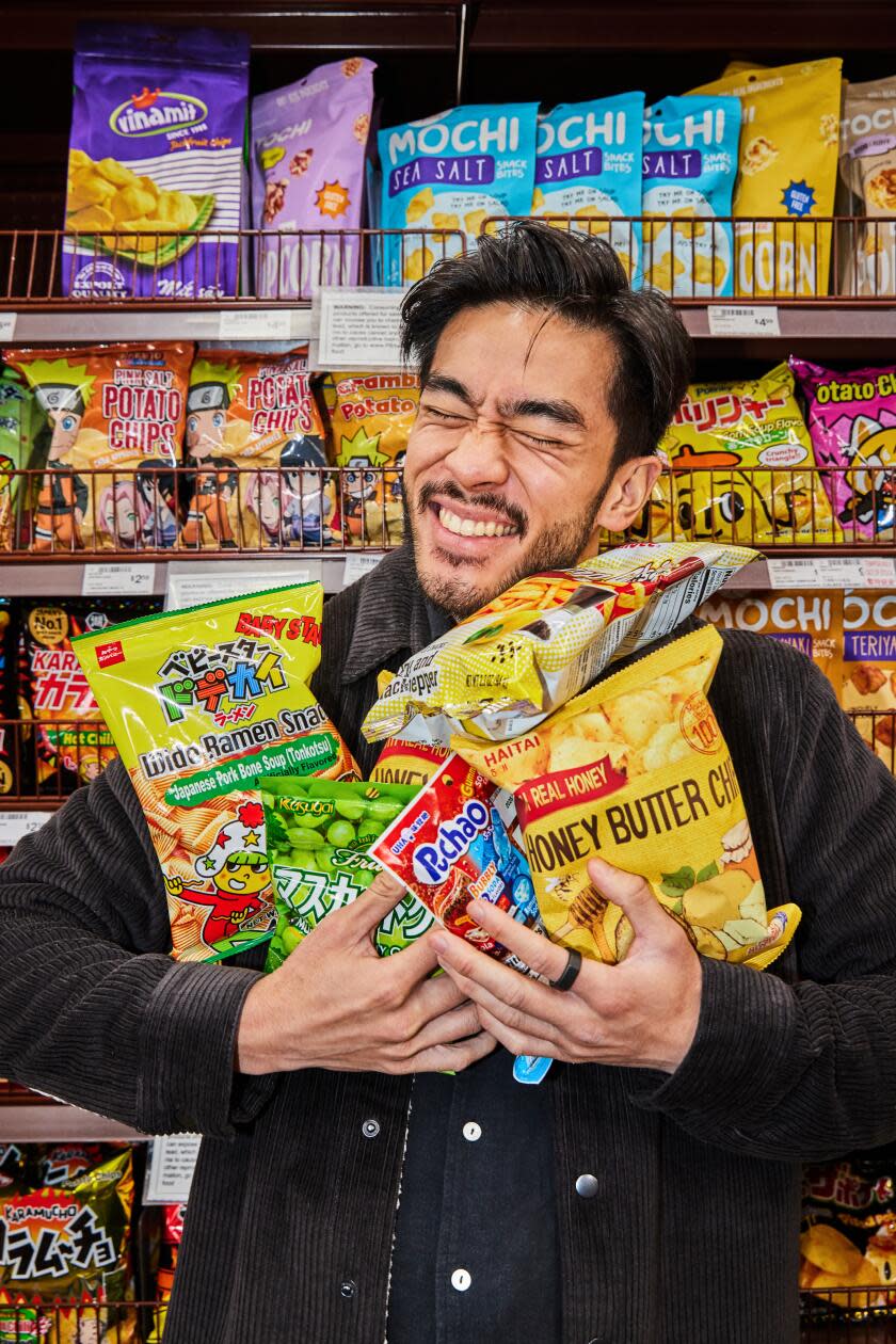 Justin Chien with his arms full of bagged snacks at 99 Ranch Market.
