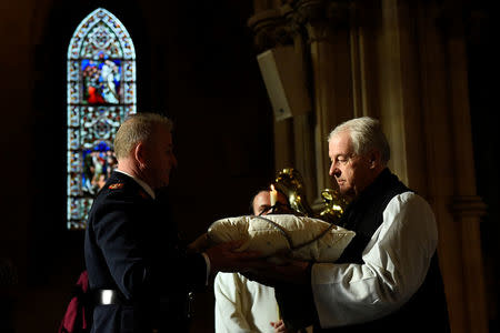 Assistant Commissioner of the Irish Police Pat Leahy returns the 800-year-old heart of the patron Saint of Dublin Laurence O'Toole to Archbishop Michael Jackson during a ceremony in Christ Church Cathedral after it was stolen six years ago, in Dublin, Ireland, April 26, 2018. REUTERS/Clodagh Kilcoyne