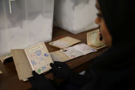 An electoral employees checks a document before closing vote for the presidential election in a polling station in Tehran, Iran, May 19, 2017. TIMA via REUTERS