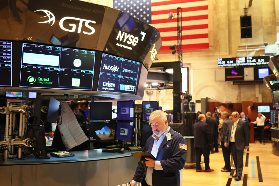 Traders work on the floor of the New York Stock Exchange as global markets rise on Thursday