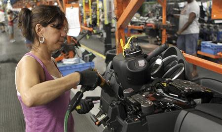 A worker installs parts onto the dashboard for the new Chevrolet Cruze car as it moves along the assembly line at the General Motors Cruze assembly plant in Lordstown, Ohio July 22, 2011. REUTERS/Aaron Josefczyk