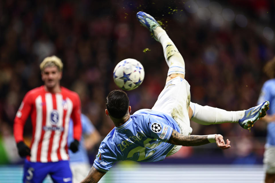 Lazio's Mattia Zaccagni tries an overhead kick on goal watched by Atletico Madrid's Rodrigo De Paul during a Group E Champions League soccer match between Atletico Madrid and Lazio at the Metropolitano stadium in Madrid, Spain, Wednesday, Dec. 13, 2023. (AP Photo/Pablo Garcia)