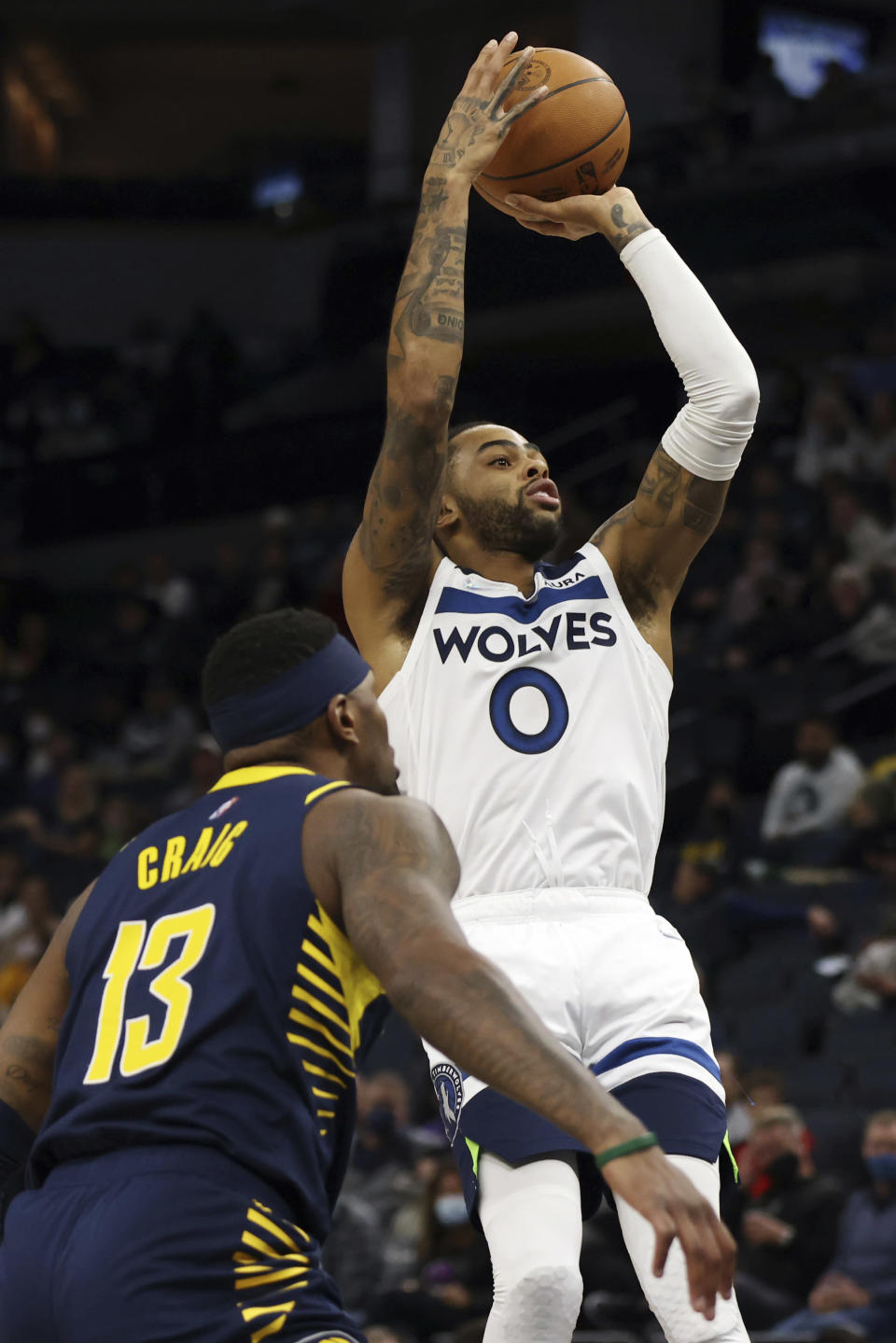 Minnesota Timberwolves guard D'Angelo Russell (0) shoots the ball against Indiana Pacers forward Torrey Craig (13) during the first half of an NBA basketball game Monday, Nov. 29, 2021, in Minneapolis. (AP Photo/Stacy Bengs)
