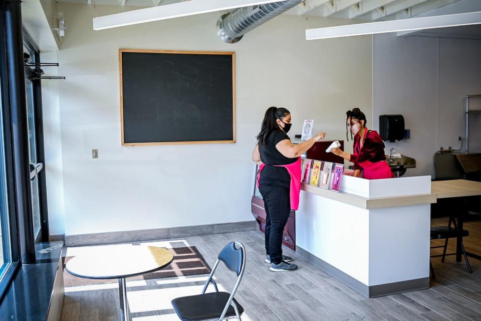 Tammara McCollum, owner of Smoothie Queen, left, and her employee Destiny Ramirez set up for business on Wednesday, March 10, 2021, in the accelerator kitchen at the Allen Neighborhood Center located at 1611 East Kalamazoo Street in Lansing.