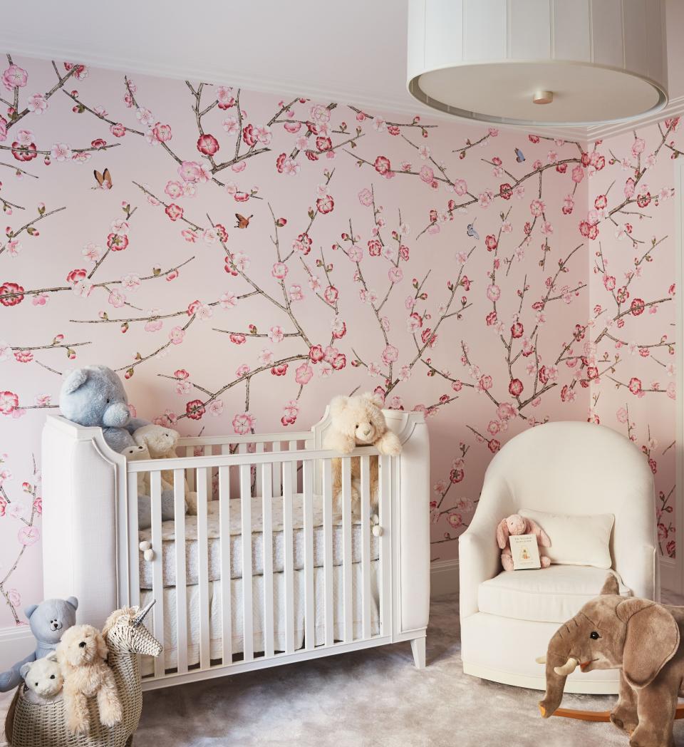 In another child’s nursery, the custom cherry blossom and butterfly wallpaper is by Brunschwig et Fils. “We were really ready for a pink room!” says Forsblom, looking back. The crib is by RH and the glider is in a washable Pollack fabric. The ceiling fixture is from Circa Lighting.